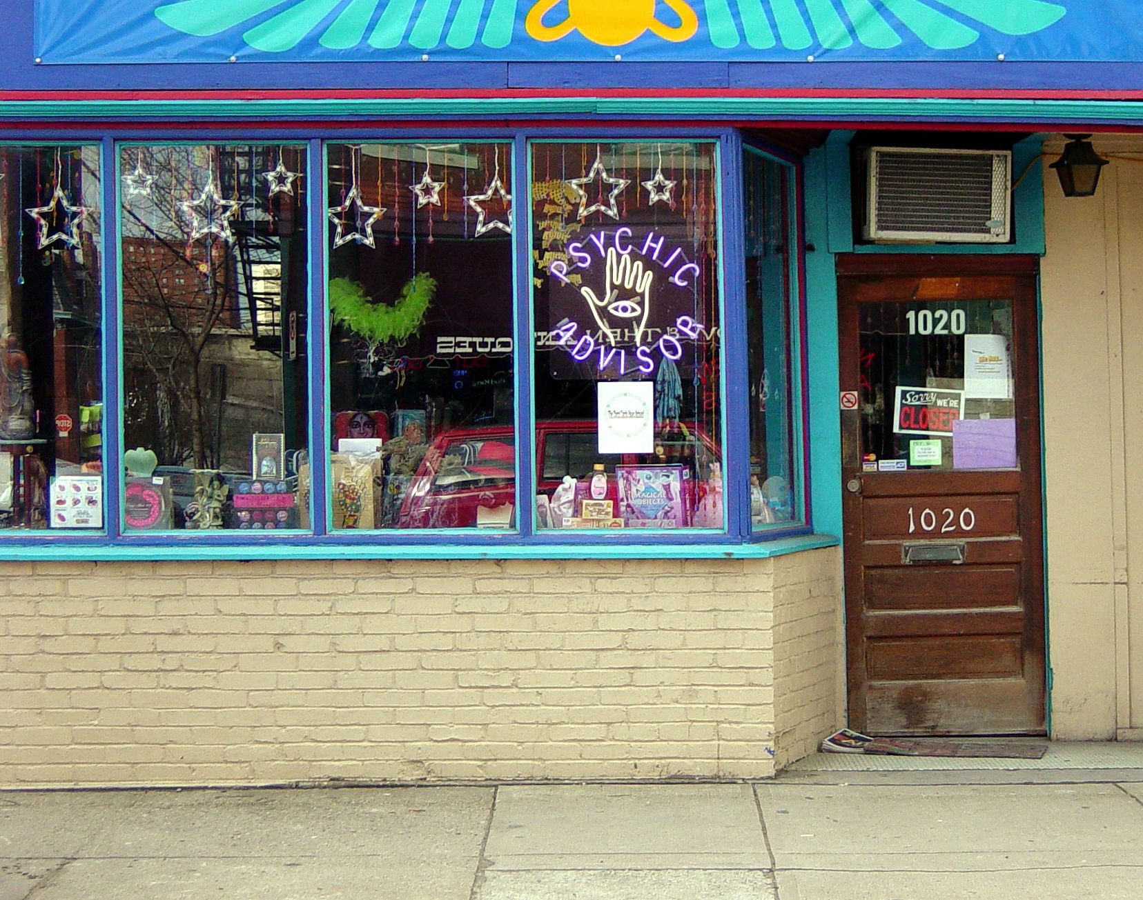 Colorful storefront with a purple and yellow sign featuring a whimsical character.