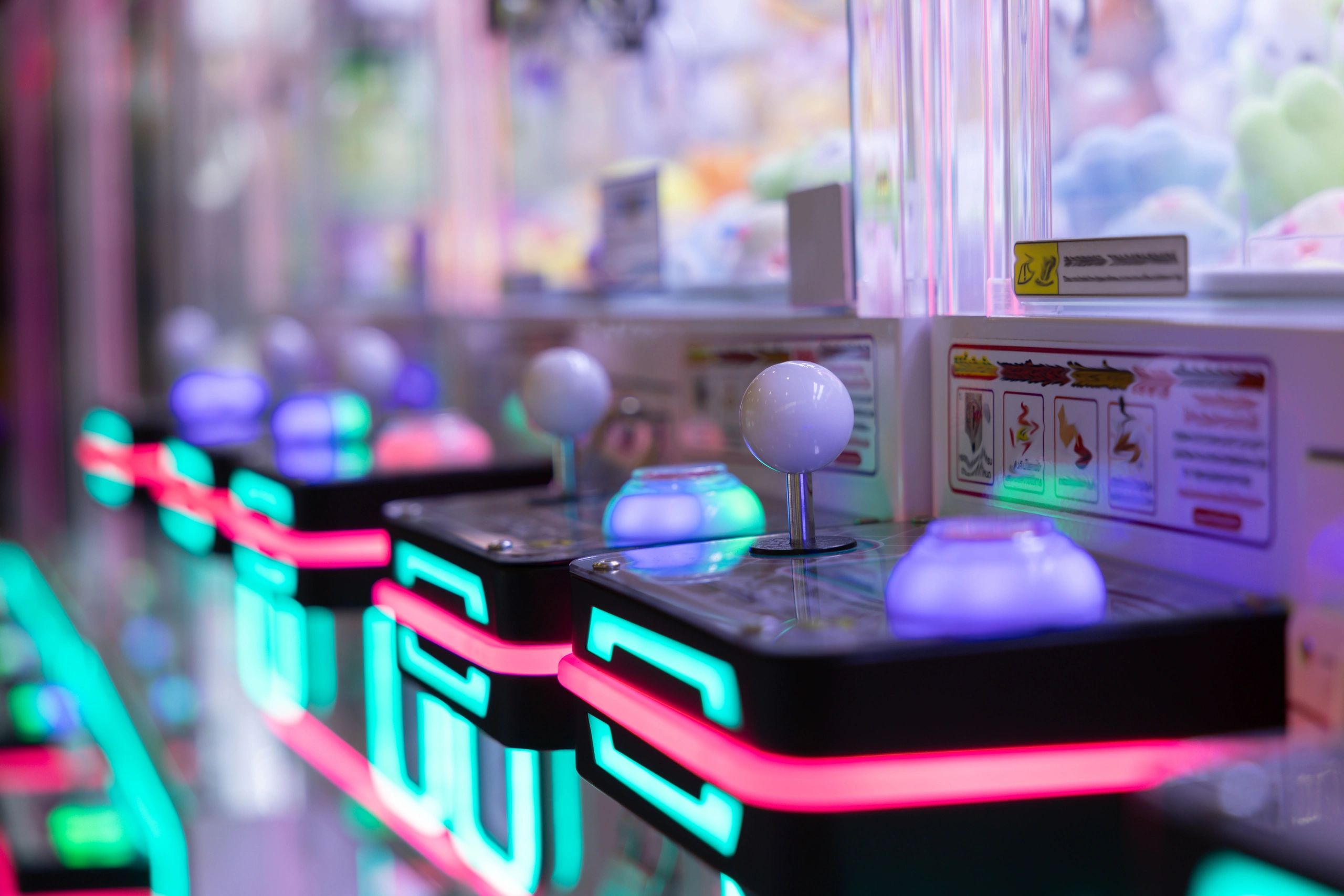 Arcade claw machine controls with colorful lights.