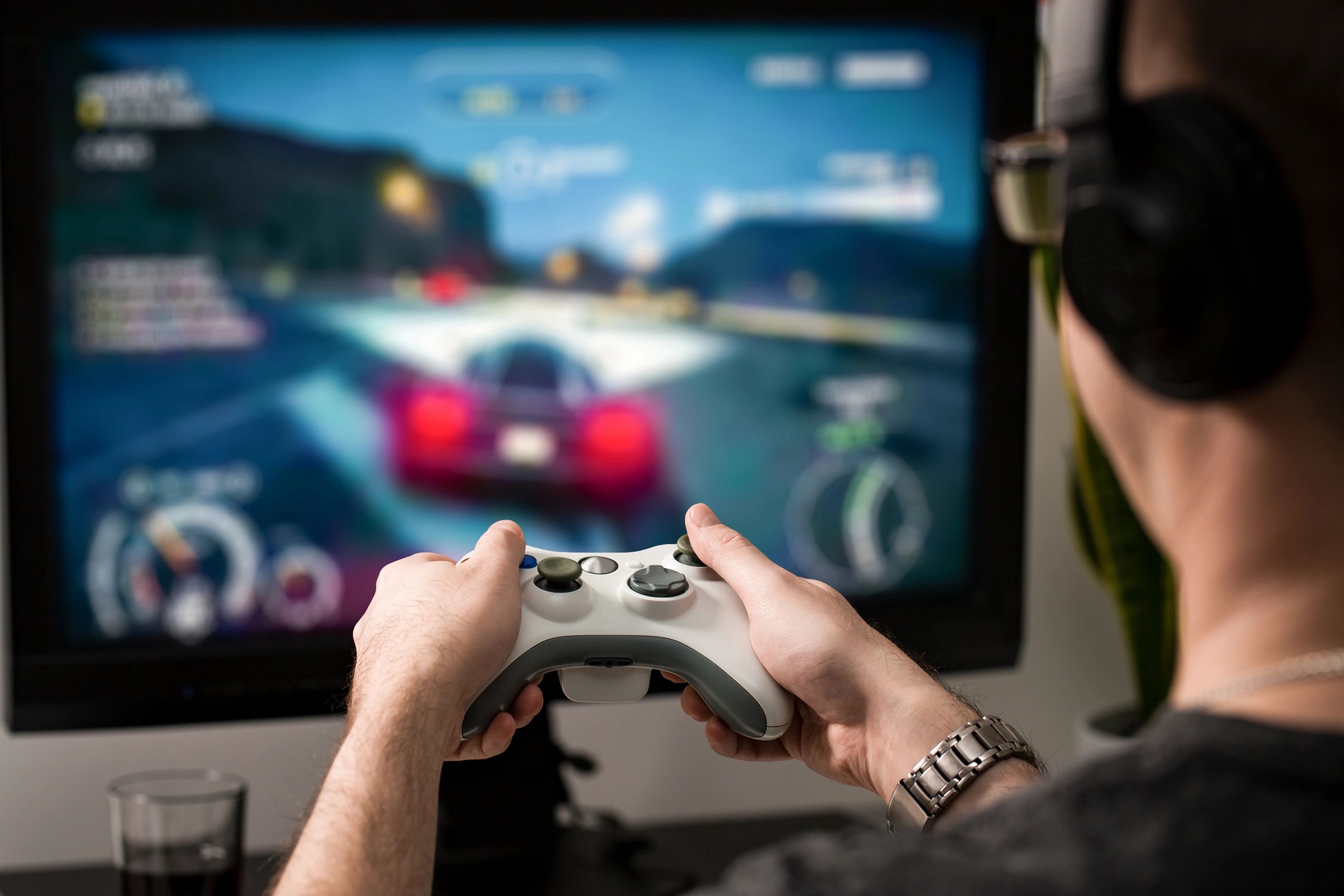 Person playing a racing video game with a controller.
